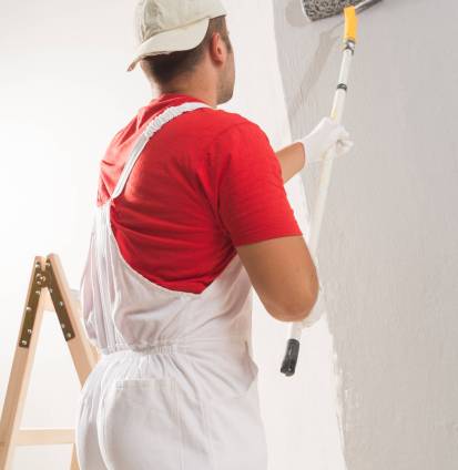 Young Man On Painting Wall With Roller